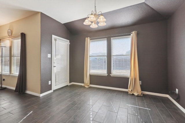 unfurnished room with a healthy amount of sunlight, lofted ceiling, and an inviting chandelier