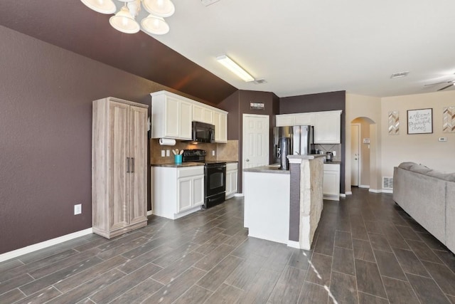 kitchen with backsplash, black appliances, ceiling fan with notable chandelier, an island with sink, and white cabinetry