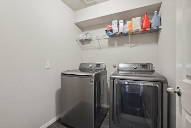 washroom with dark tile patterned floors and independent washer and dryer