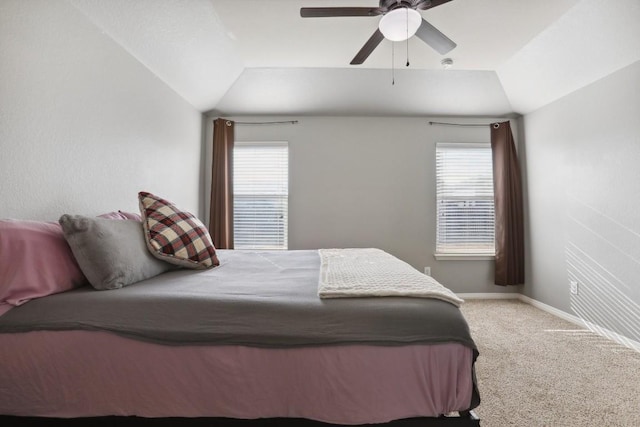 carpeted bedroom with multiple windows, ceiling fan, and lofted ceiling