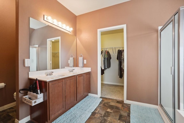 bathroom with vanity, toilet, and a shower with door