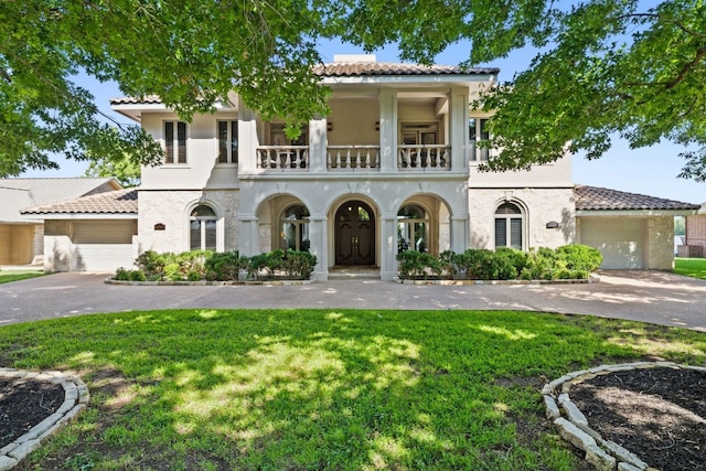 mediterranean / spanish-style home featuring a balcony and a front yard