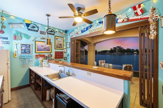 kitchen featuring butcher block countertops, sink, and pendant lighting