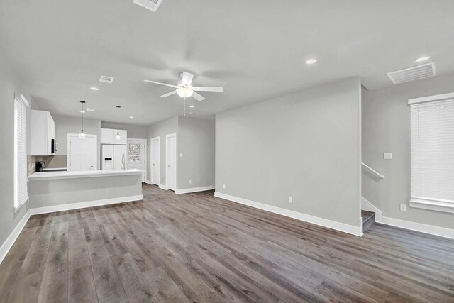 unfurnished living room featuring dark hardwood / wood-style floors, ceiling fan, and sink