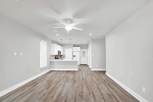 unfurnished living room featuring light wood-type flooring and ceiling fan