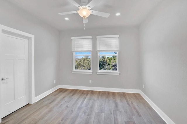 empty room with ceiling fan and light hardwood / wood-style flooring