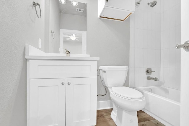 full bathroom with ceiling fan, toilet, hardwood / wood-style flooring, vanity, and tiled shower / bath