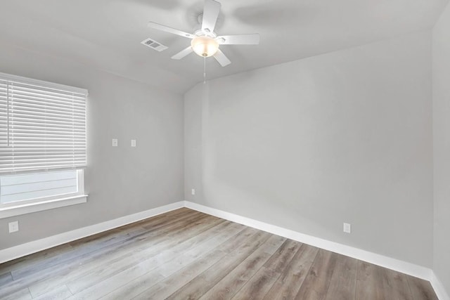 spare room featuring ceiling fan, light hardwood / wood-style floors, and vaulted ceiling