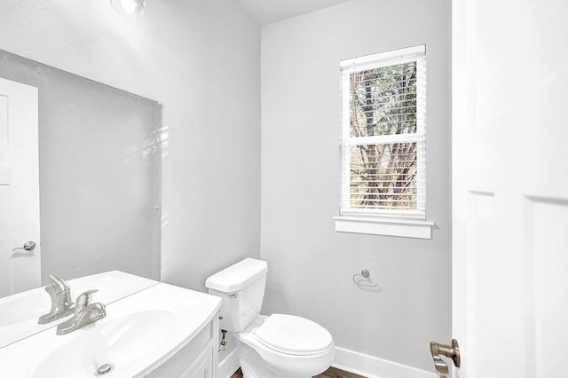 bathroom featuring a wealth of natural light, vanity, and toilet