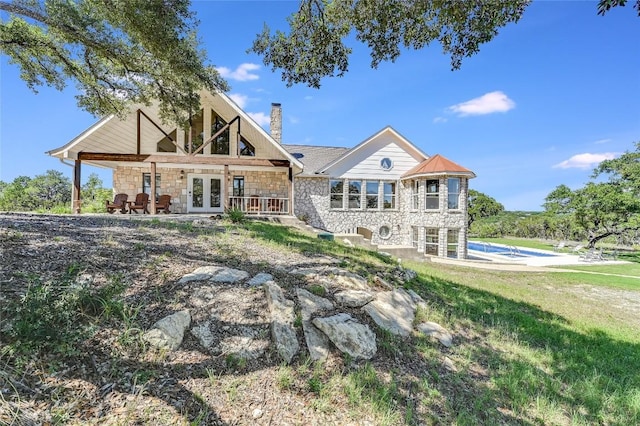 rear view of house with a lawn and french doors