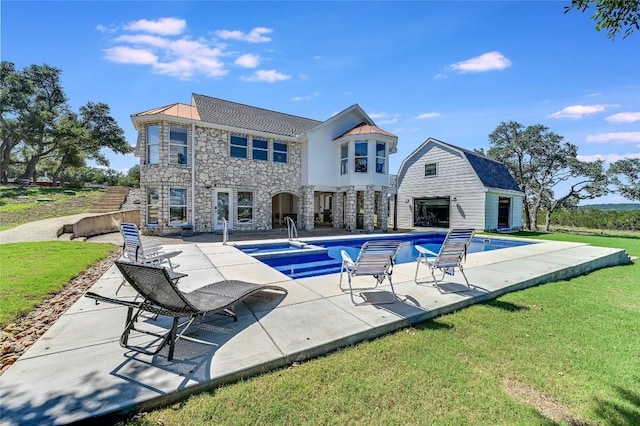 back of house featuring a lawn, an outdoor structure, and a patio