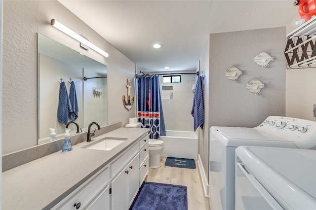 full bathroom featuring shower / bath combo, vanity, toilet, wood-type flooring, and washing machine and clothes dryer