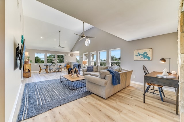 living room featuring light wood-type flooring, vaulted ceiling, ceiling fan, and a healthy amount of sunlight