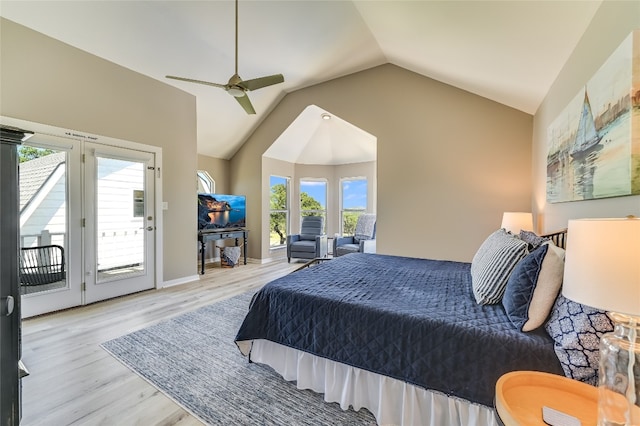 bedroom featuring access to exterior, ceiling fan, light hardwood / wood-style flooring, vaulted ceiling, and multiple windows