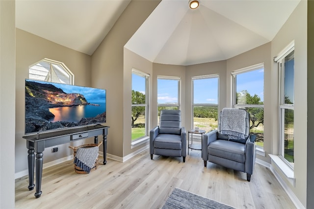 sitting room featuring a healthy amount of sunlight, lofted ceiling, and light wood-type flooring