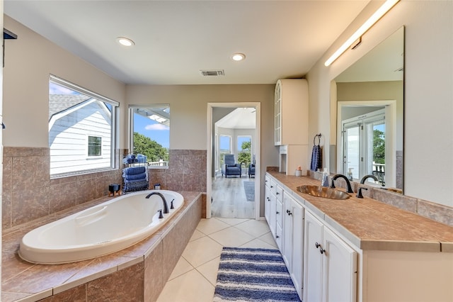 bathroom featuring vanity, tile patterned floors, and tiled tub