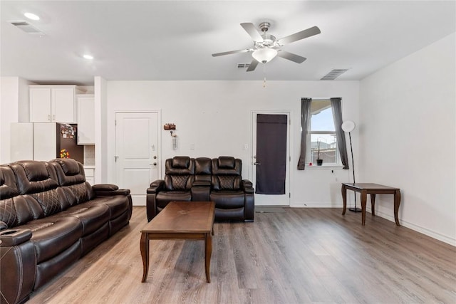 living room featuring light hardwood / wood-style floors and ceiling fan