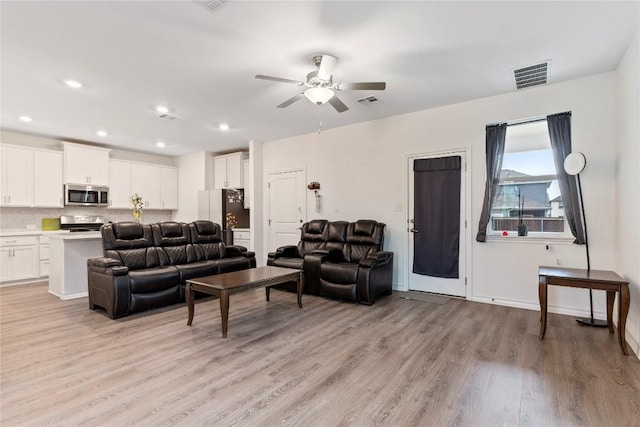 living room featuring ceiling fan and light hardwood / wood-style flooring