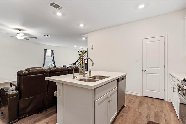 kitchen featuring stainless steel appliances, a kitchen island with sink, sink, light hardwood / wood-style floors, and white cabinetry