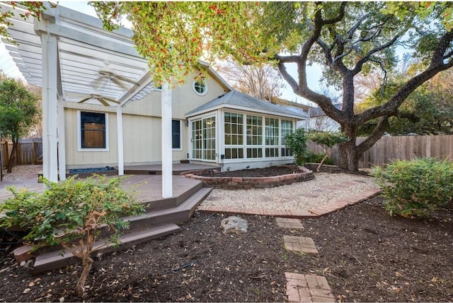 back of house with a pergola, a deck, and a sunroom