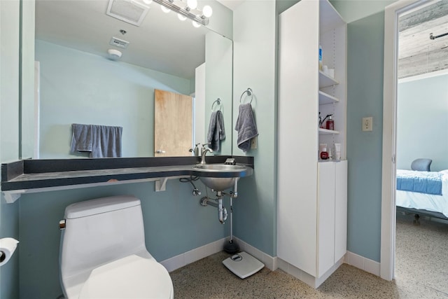 710 Colorado St Unit 5F, Austin, TX 78701 - bathroom with speckled floor, baseboards, ensuite bathroom, and toilet