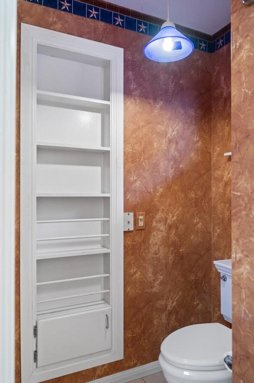 bathroom featuring tile patterned flooring, built in features, and toilet