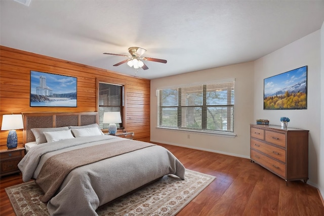 118 S S Cv, Spicewood, TX 78669 - bedroom with wood walls, baseboards, wood finished floors, and ceiling fan