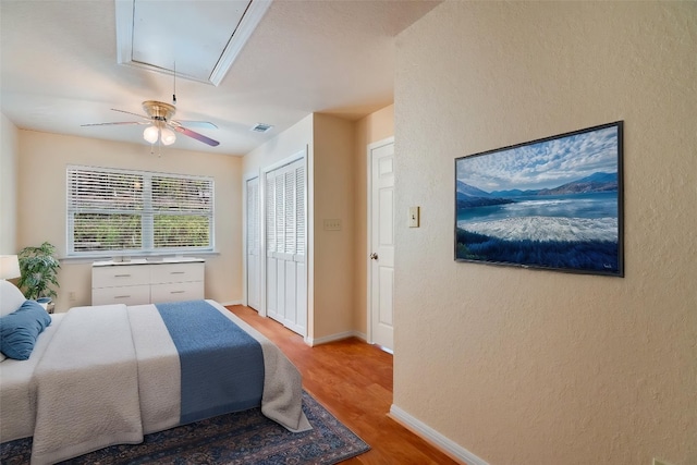 118 S S Cv, Spicewood, TX 78669 - bedroom featuring attic access, wood finished floors, baseboards, a closet, and ceiling fan