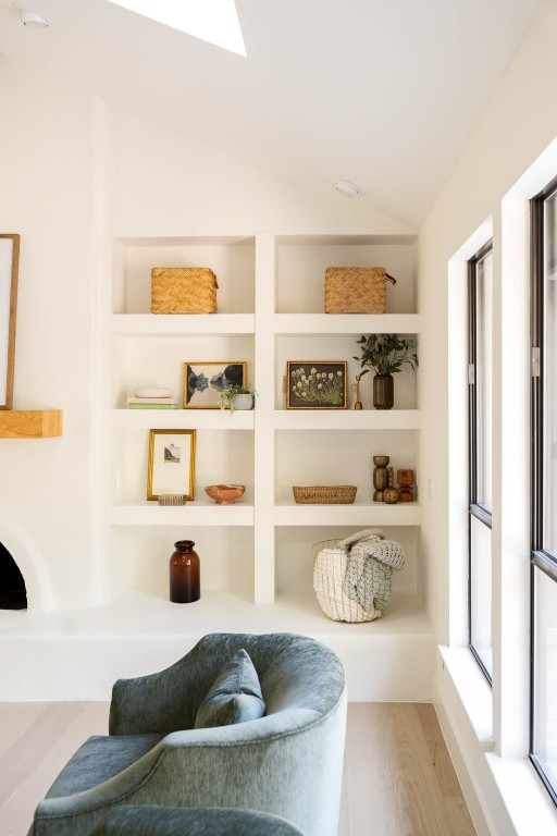 living area with wood-type flooring and vaulted ceiling