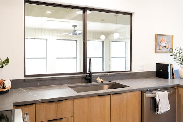 kitchen with dishwasher, sink, and dark stone counters