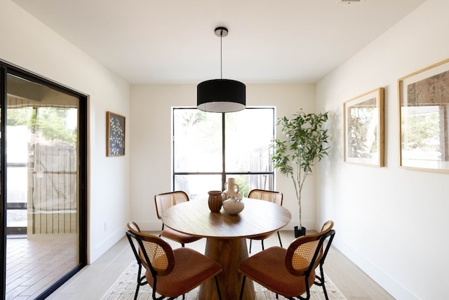 dining area featuring light wood-type flooring and plenty of natural light