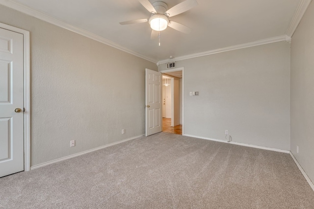 spare room with ceiling fan, light colored carpet, and ornamental molding