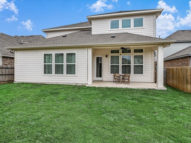 rear view of house with a patio, a lawn, and a fenced backyard