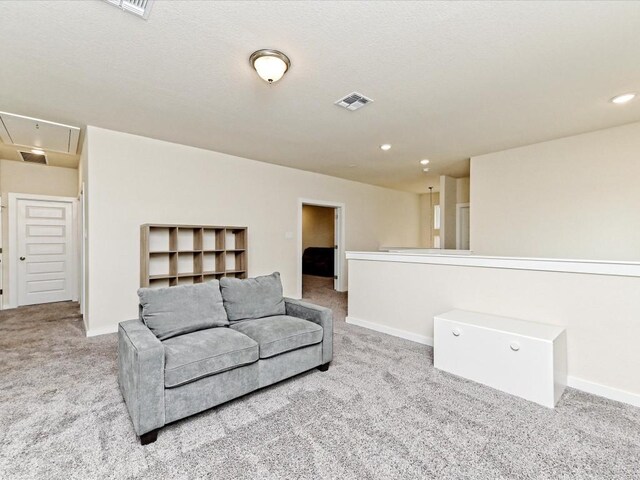 carpeted living area with visible vents, recessed lighting, attic access, and baseboards