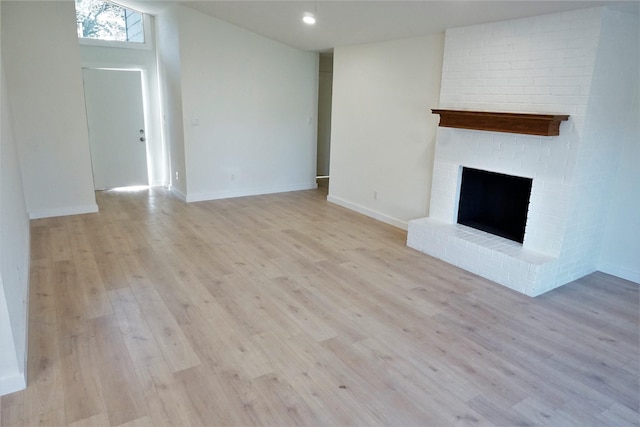 unfurnished living room with a fireplace and light hardwood / wood-style flooring