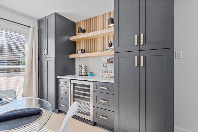 bar with gray cabinets and beverage cooler