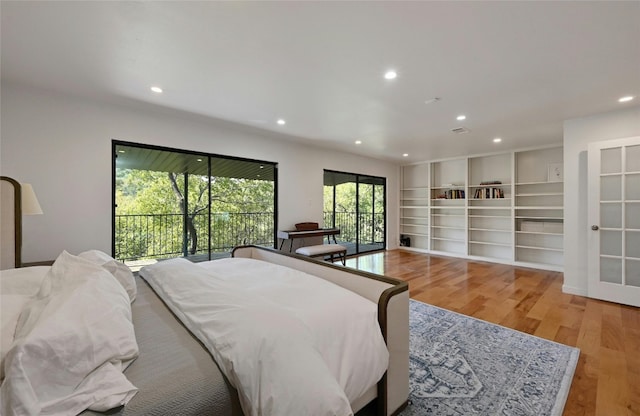 bedroom featuring access to exterior and hardwood / wood-style floors