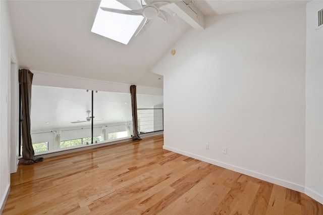 unfurnished living room featuring ceiling fan, vaulted ceiling with skylight, and hardwood / wood-style flooring