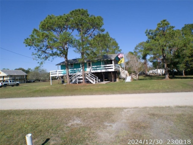 view of front facade featuring a front yard and a wooden deck