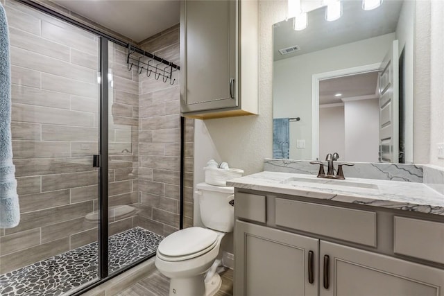 bathroom featuring visible vents, a shower stall, toilet, and vanity