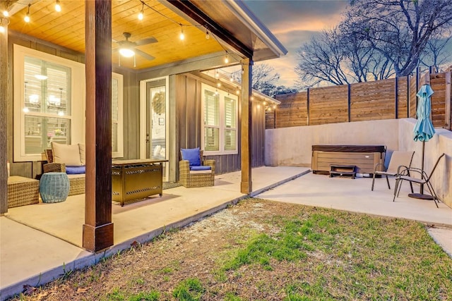 view of patio with ceiling fan, a hot tub, and fence