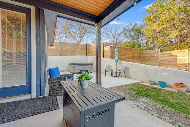 view of patio / terrace with a fenced backyard and a hot tub