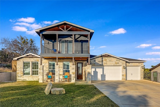 view of front of home with driveway, a balcony, stone siding, an attached garage, and a front yard