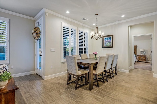 dining area with ornamental molding, a wealth of natural light, a notable chandelier, and light wood finished floors