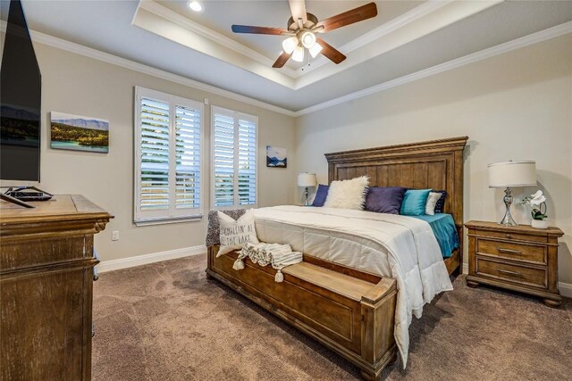 bedroom with a ceiling fan, baseboards, a tray ceiling, carpet, and crown molding