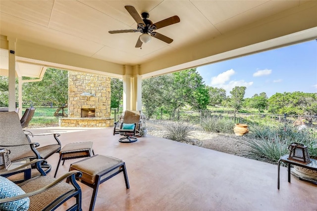 view of patio / terrace featuring ceiling fan and an outdoor stone fireplace