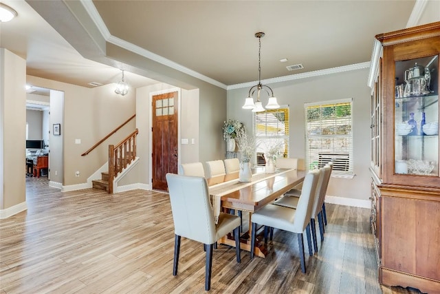 dining area featuring ornamental molding, a chandelier, and wood-type flooring