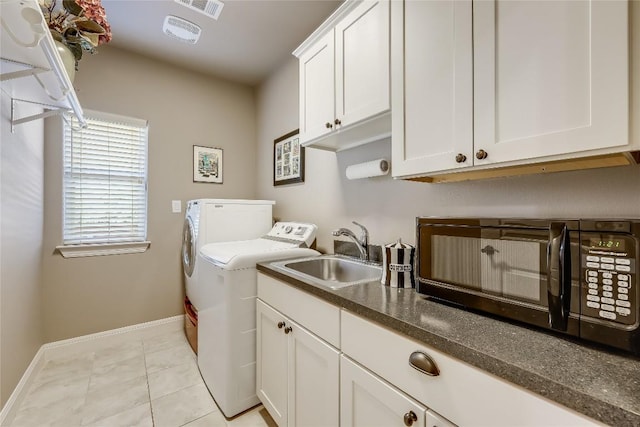 laundry area with cabinets, separate washer and dryer, light tile patterned flooring, and sink