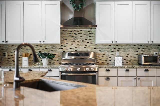 3500 Lohmans Ford Rd Unit 71, Lago Vista, TX 78645 - kitchen with wall chimney exhaust hood, gas stove, tasteful backsplash, white cabinets, and light stone countertops
