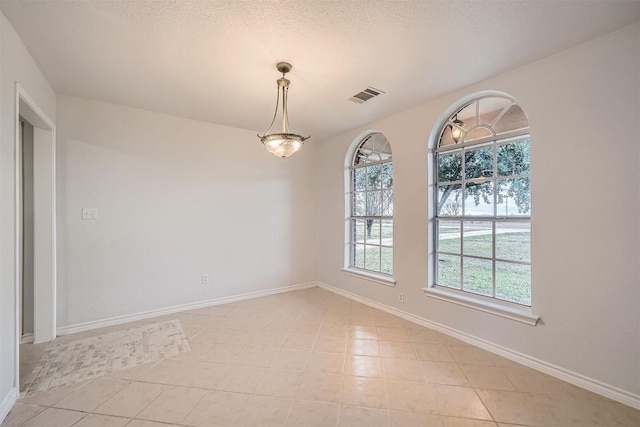 unfurnished dining area featuring light tile patterned floors and a textured ceiling